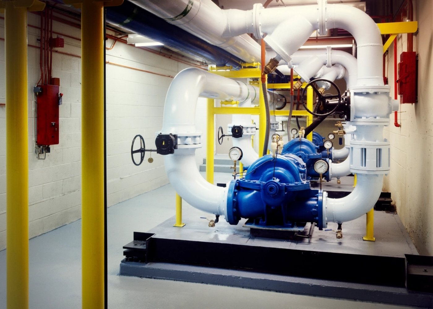 Pipework and a circulating pump in a plant room (illustrative stock photograph)